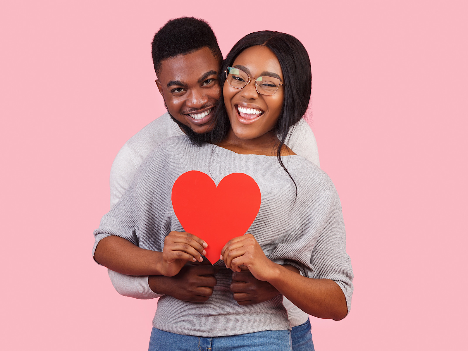 Joyful african couple holding big red heart together by Prostock-studio